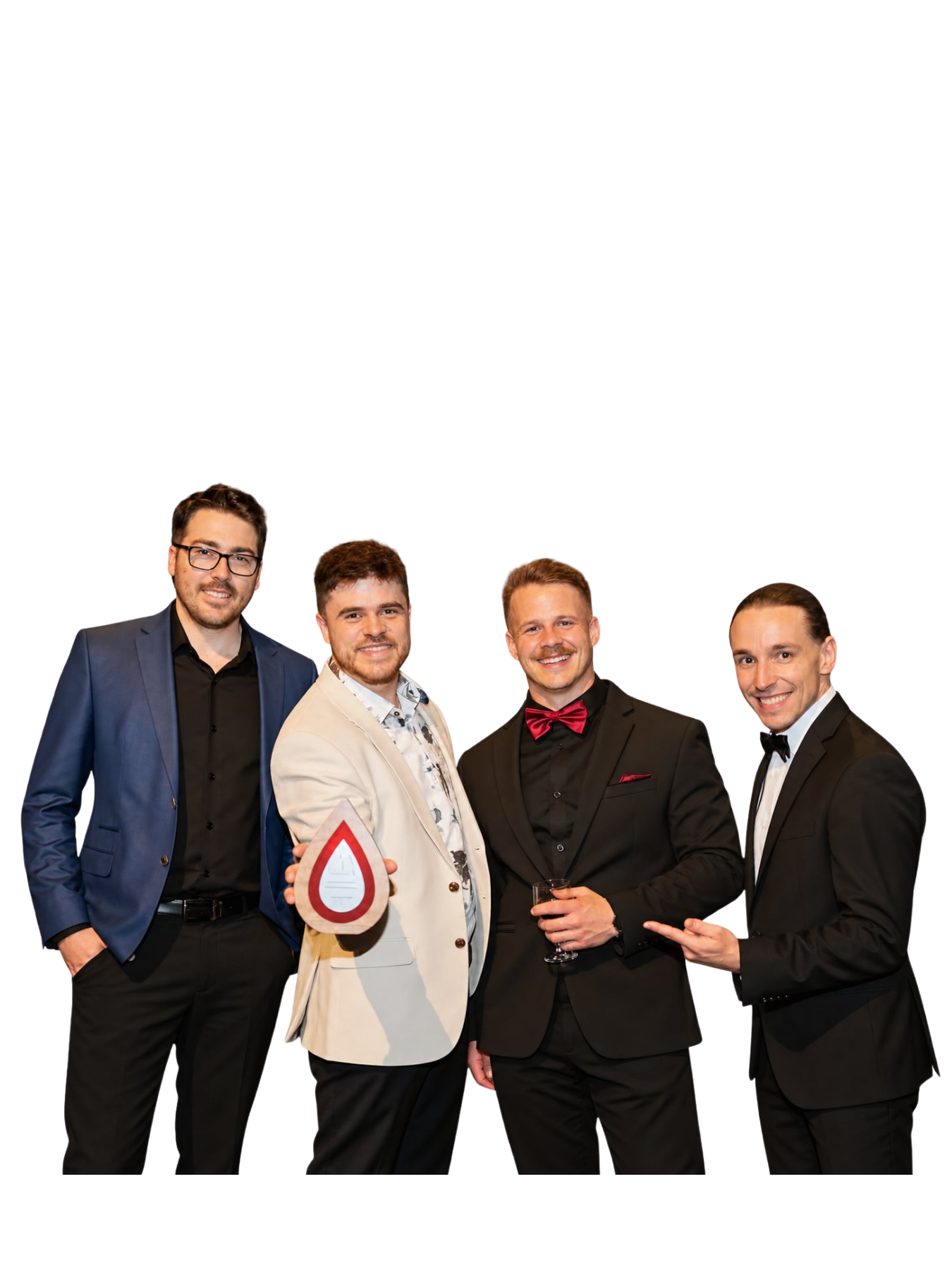 Quatre hommes souriants réunis, dont un tient un trophée.
